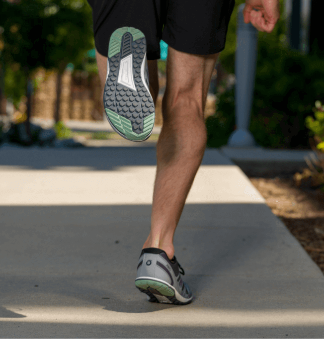 Lower leg view of a man running on a sidewalk in HFS II running shoes